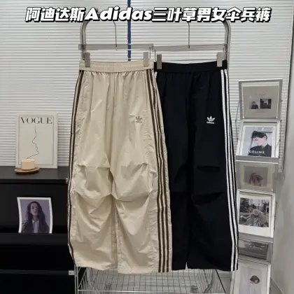 款号3325 阿迪达斯adidas三叶草经典三条杠伞兵裤|街头潮人必入的神裤!阿迪达斯男女情侣款长裤 🔥 复古运动风拉满,百搭不挑人 经典三叶草logo+侧边三条杠设计,一秒拉回90年代复古运动潮流,不管是街头风、休闲风还是Y2K风都能轻松驾驭,随便搭件白T、卫衣就超有氛围感,出街回头率直接拉满! 👖 梨形身材天菜,藏肉又显腿直 宽松阔腿的工装版型,自带的膝盖褶皱设计,巧妙修饰胯宽、腿粗、O型腿等所有身材bug,从腰到腿线条直到犯规,轻松穿出“头以下都是腿”的既视感,小个子也能秒变1米8大长腿! ☁️ 轻盈透气面料,四季都好穿 采用高克重尼龙褶皱面料,自带肌理感,抗皱又耐磨,摸起来轻薄又有垂坠感,夏天穿不闷汗,春秋搭配也不厚重,日常通勤、运动、逛街穿都舒服到不想脱下来! ⚙️ 细节控狂喜,实用与颜值并存 • 弹力松紧腰+抽绳设计,不挑腰围,吃撑也毫无束缚感 • 侧边大口袋设计,实用又能增加工装层次感 • 防泼水面料,小雨天也能从容应对,日常打理超省心 • 男女同款设计,情侣一起穿潮酷翻倍! 颜色:黑色 米白色